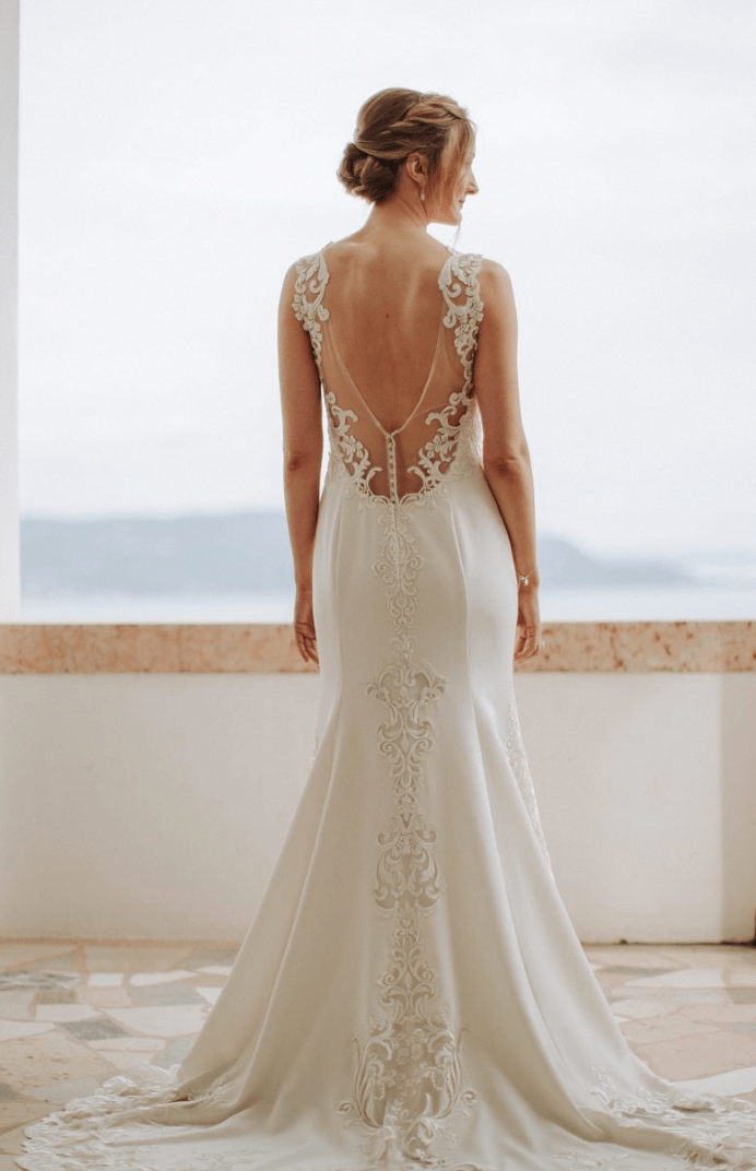 Italian bride wearing her lace gown overlooking the sea.