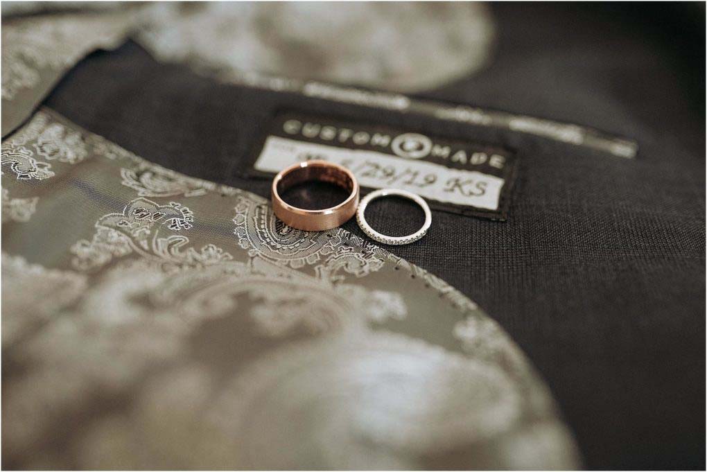 The bride and grooms rings sit on top of his custom made jacket.