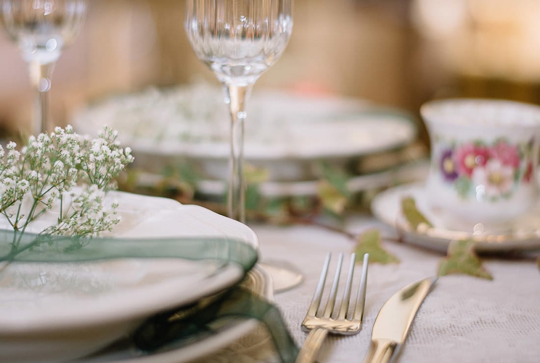Close up of a wedding reception table with teacup and saucer and a champagne flute.